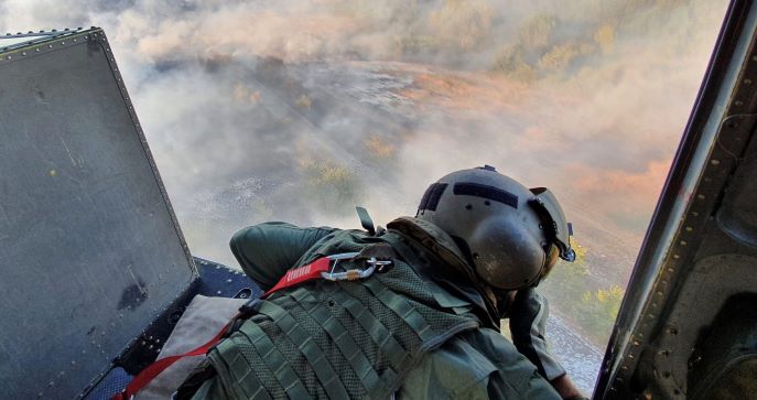 Militare dell'Esercito Italiano osserva incendi in elicottero