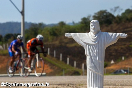 Ciclisti e una statuetta del Cristo di Rio